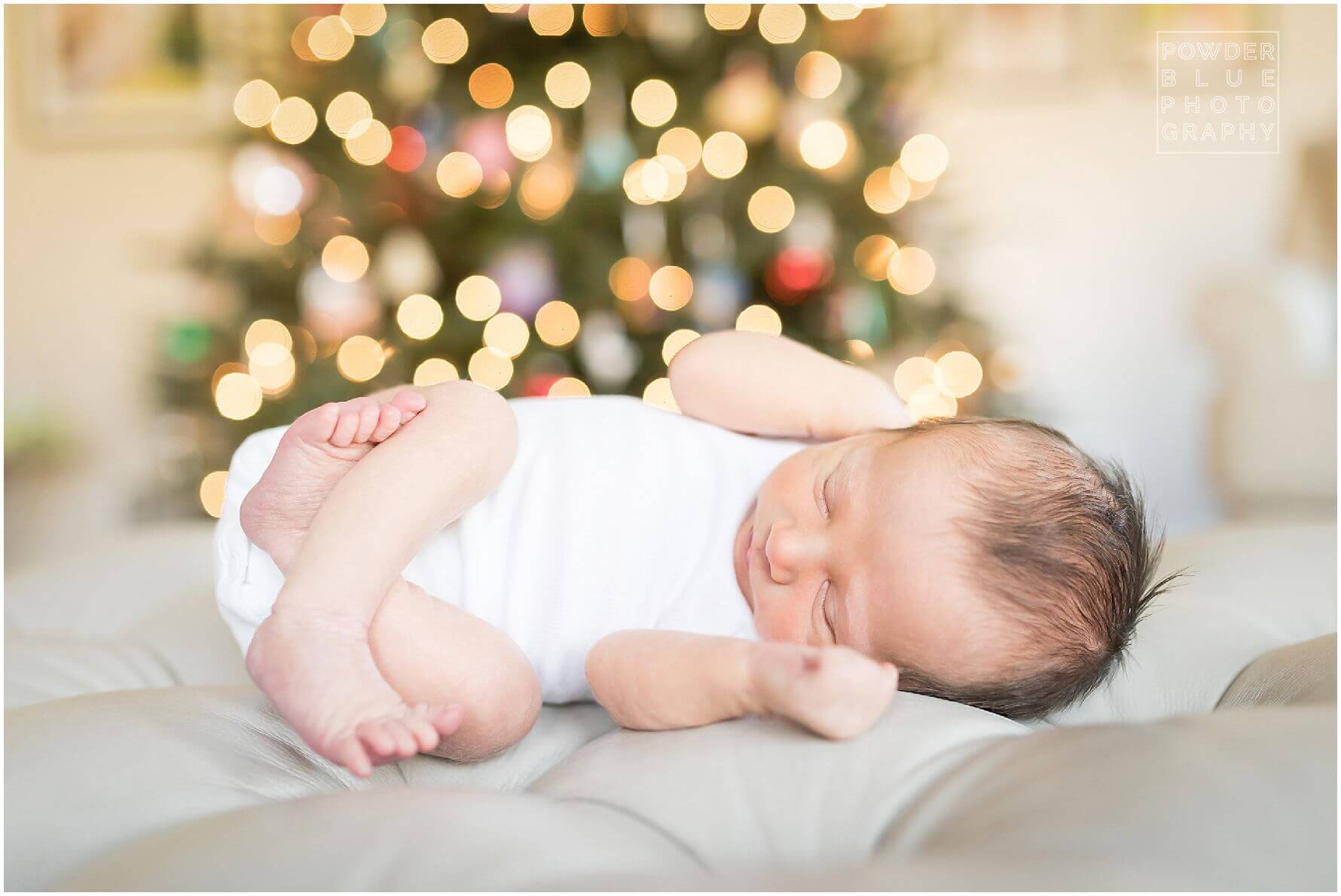 pittsburgh newborn photographer missy timko photographed this baby iboy in front of the christmas tree with twinkling lights behind him. wide open aperture with christmas tree as backdrop.